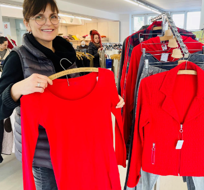 Frau kauft rotes Shirt in Umwelt-Werkstatt ein